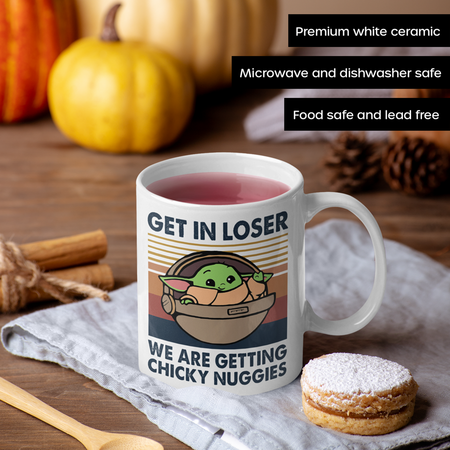 A white ceramic coffee mug featuring an illustration of Grogu in a hover pram with the funny phrase "Get In Loser, We Are Getting Chicky Nuggies." The design is printed on both sides, making it perfect for right- or left-handed users. A cute and humorous gift for sci-fi fans, coffee lovers, and pop culture enthusiasts.