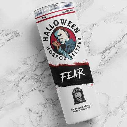 A white insulated tumbler with a clear lid, featuring a Halloween horror-themed label with Michael Myers artwork and the words 'HALLOWEEN HORROR SELTER' and 'FEAR', photographed on a white marble surface.