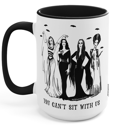 A white ceramic mug with a black handle and black interior, featuring a black line art illustration of four gothic women and the text 'YOU CAN'T SIT WITH US' on the front.